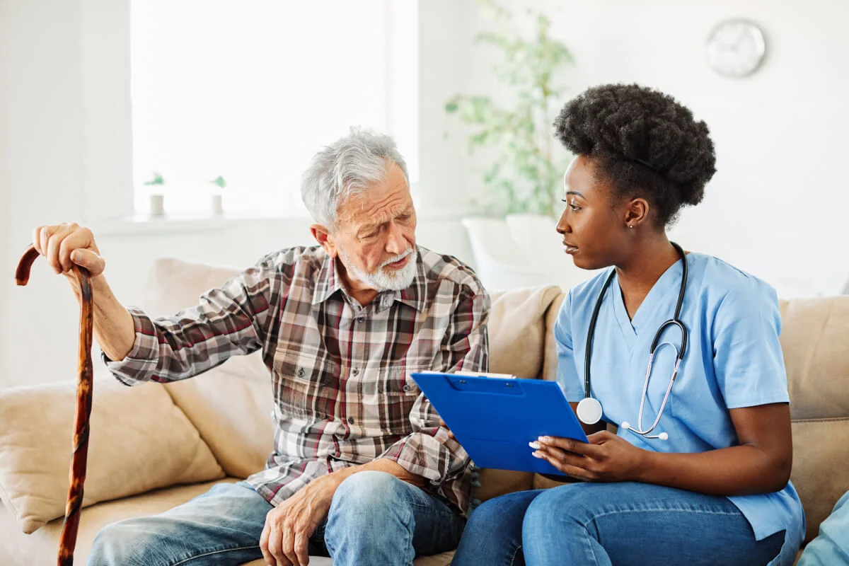 A nurse reviewing a care plan with an older man at home